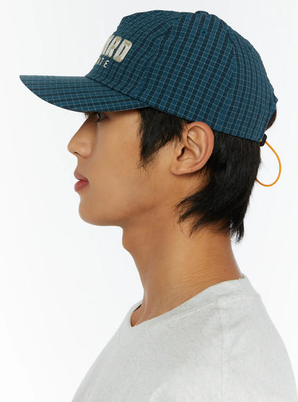 Plaid Embroidered Cap IL515 Dark blue back view on male model showing orange elastic cord adjuster and grid check ripstop fabric