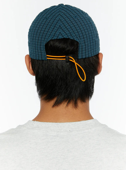 Plaid Embroidered Cap IL515 Dark blue full-length front model shot male model arms raised behind head styled with gray graphic tee and dark jeans