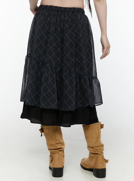Plaid Layered Midi Skirt IL522 Black back shot on model cropped waist-down view showing elastic waistband sheer plaid tiered back panel black underlayer and tan knee-high boots
