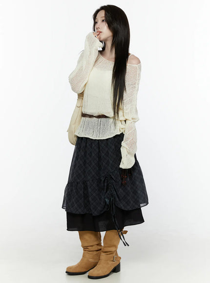 Plaid Layered Midi Skirt IL522 Black full-length side shot on model styled with cream open-knit sweater belt shoulder bag hand near chin dynamic pose tan boots