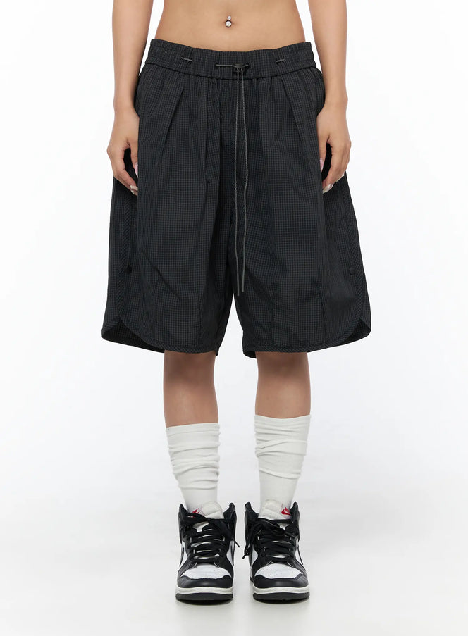 Plaid Nylon Shorts CU523 Black front view on model, wide-leg grid-texture nylon shorts with elastic drawstring waist, size M
