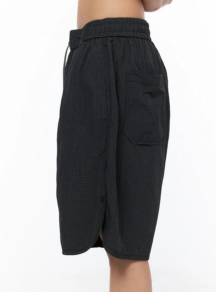 Plaid Nylon Shorts CU523 Black side close-up on model, highlighting cargo pocket, side slit hem, and grid-textured nylon fabric construction