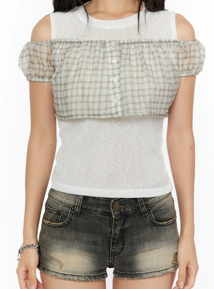 Plaid Off-Shoulder Crop Top CU526 Beige close-up front detail shot on model, beige plaid ruffle panel with pearl button placket over sheer ribbed knit crop, cold-shoulder cutouts, ruffled smocked hem
