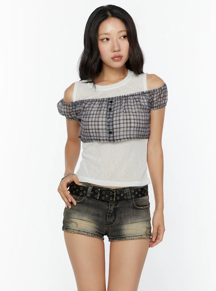 Plaid Off-Shoulder Crop Top CU526 Beige front shot on model, plaid ruffle bust overlay with button placket over white sheer knit crop, cold-shoulder cutouts, styled with distressed denim shorts