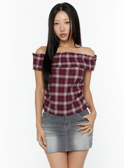 Plaid Off-Shoulder Shirt CU529 Red front model shot with hand on hip showing fitted waist smocked neckline and plaid flannel fabric paired with gray denim skirt