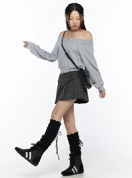 Plaid Pleated Mini Skirt CL527 Gray full-body model front shot styled with gray off-shoulder crop sweatshirt and black crossbody bag with knee-high boots