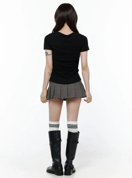 Plaid Pleated Mini Skirt IL506 Brown full-body back shot on model standing straight showing smooth back panel plaid fabric and box pleats styled with black top striped socks and buckle boots