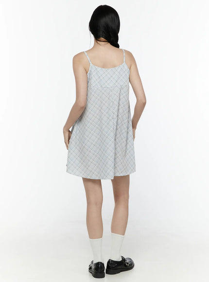 Plaid Shirred Cami Mini Dress IL506 Light blue back model shot showing clean open back spaghetti straps back pleat and A-line skirt with white socks and loafers