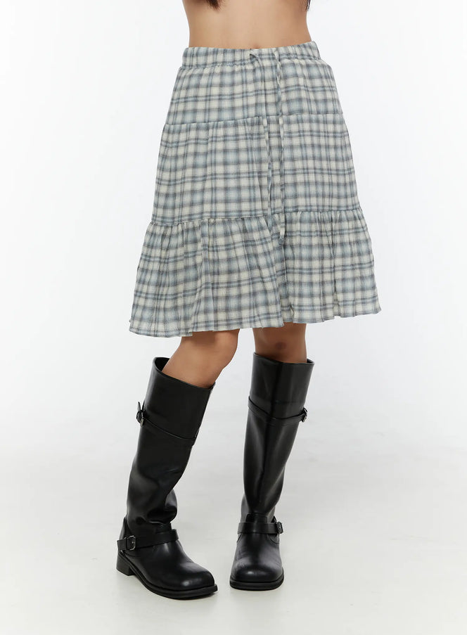 Plaid Tiered Midi Skirt CU529 Light blue side close-up on model showing elastic drawstring waist and tiered ruffle hem with black knee-high boots