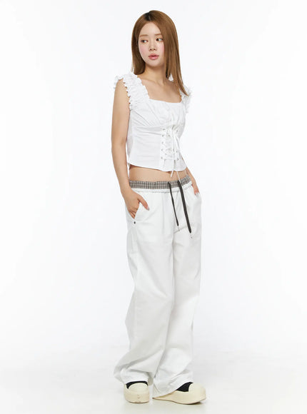 Plaid Waistband Wide-Leg Trousers CL502 White three-quarter front model shot with hand in pocket showing plaid contrast waistband and full-length wide leg