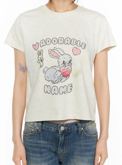 Playful Print Cropped T-Shirt CU530 cream torso close-up on model revealing full graphic bunny heart print and cropped hem