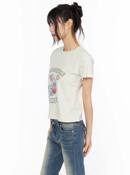 Playful Print Cropped T-Shirt CU530 cream side shot on model showing short sleeve silhouette and bunny graphic with denim jeans