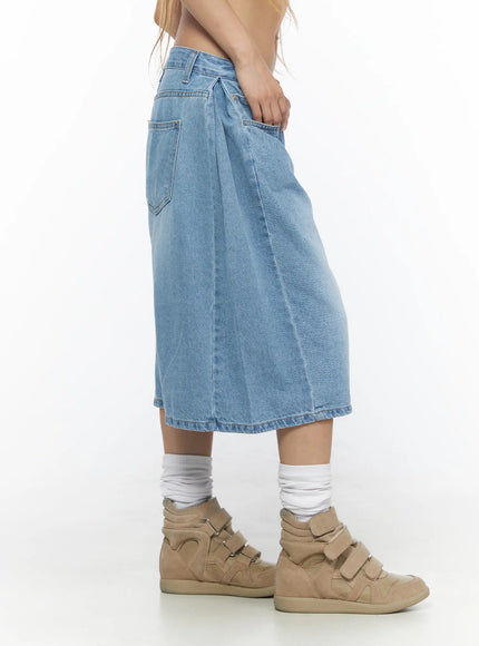 Pleated Denim Jorts CL528 light blue side shot on model with hand in pocket showing knee-length hem and wide-leg denim silhouette