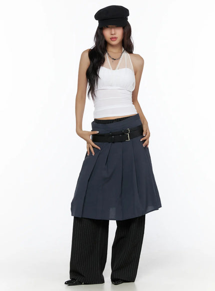 Pleated Midi Wrap Skirt CL513 navy blue full-length front shot model standing upright wearing pleated wrap skirt over black pinstripe wide-leg pants with black leather double buckle belt