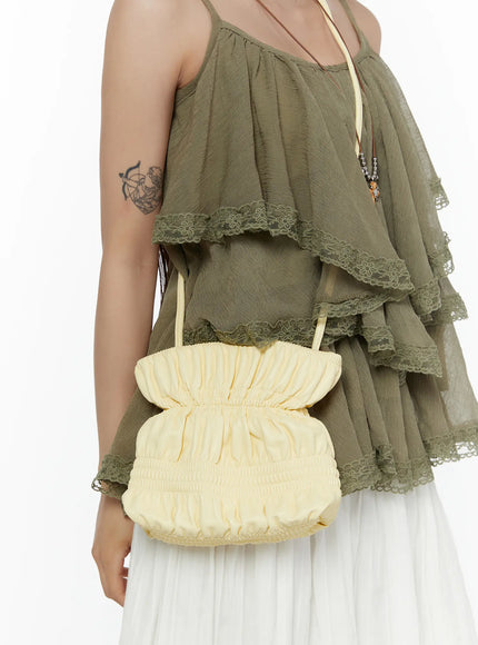 LEWKIN Pleated Mini Crossbody Bag CL507 Yellow close-up on model styled crossbody with ruched fabric texture paired with olive lace-trim cami top