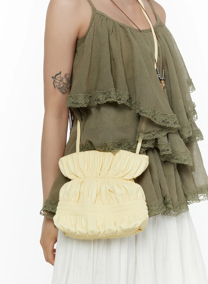 LEWKIN Pleated Mini Crossbody Bag CL507 Yellow close-up on model styled crossbody with ruched fabric texture paired with olive lace-trim cami top