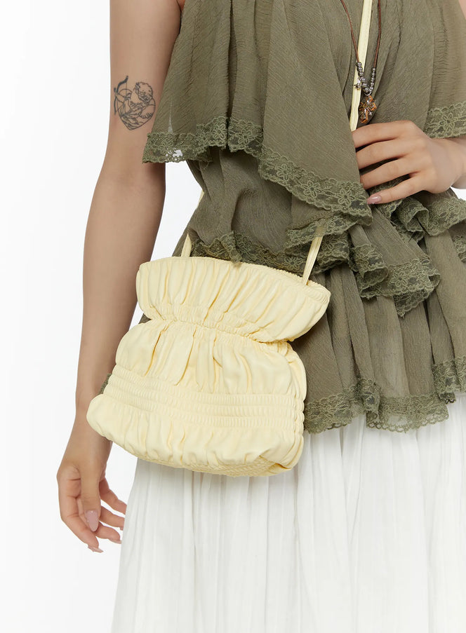 Pleated Mini Crossbody Bag CL507 Yellow side close-up on model held at hip showing gathered ruched structure and slim strap detail