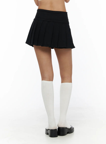 Pleated Mini Skirt CL503 Black back shot on model showing rear pleats and clean wide waistband with white knee socks and platform sandals
