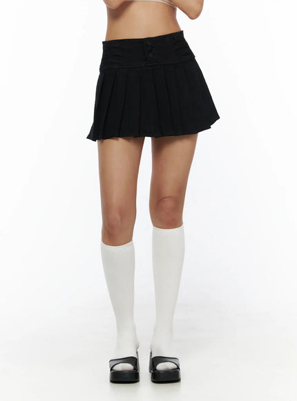 Pleated Mini Skirt CL503 Black front three-quarter shot on model showing ruched waistband buttons and flared pleated skirt with white knee socks