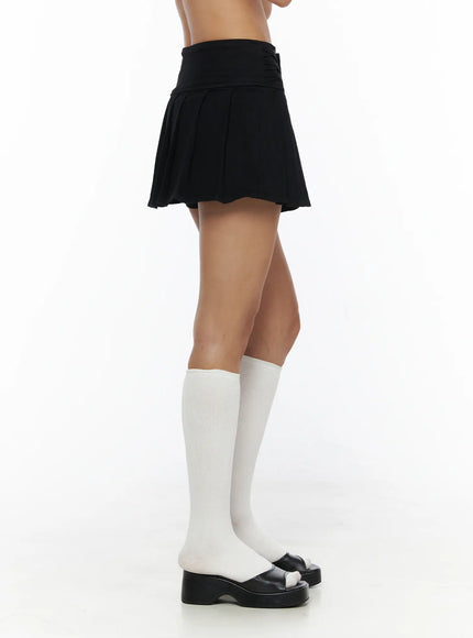 Pleated Mini Skirt CL503 Black side shot on model showing pleated silhouette and folded waistband detail with white knee-high socks