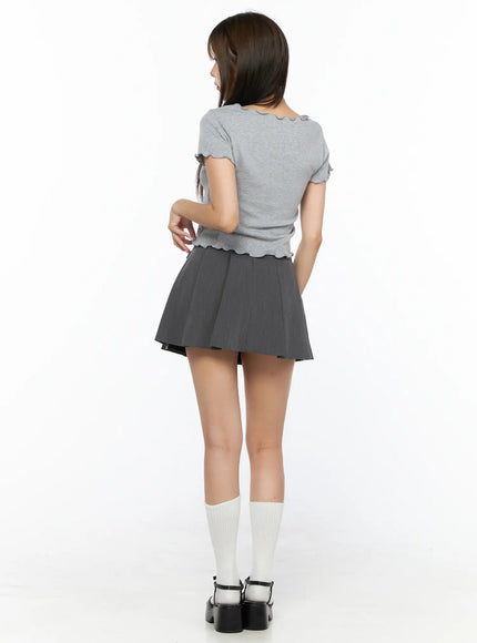 Pleated Mini Skirt CL517 Gray full-body back shot on model showing pleated back hem, no belt visible, gray crop tee, white knee socks and black Mary Jane heels