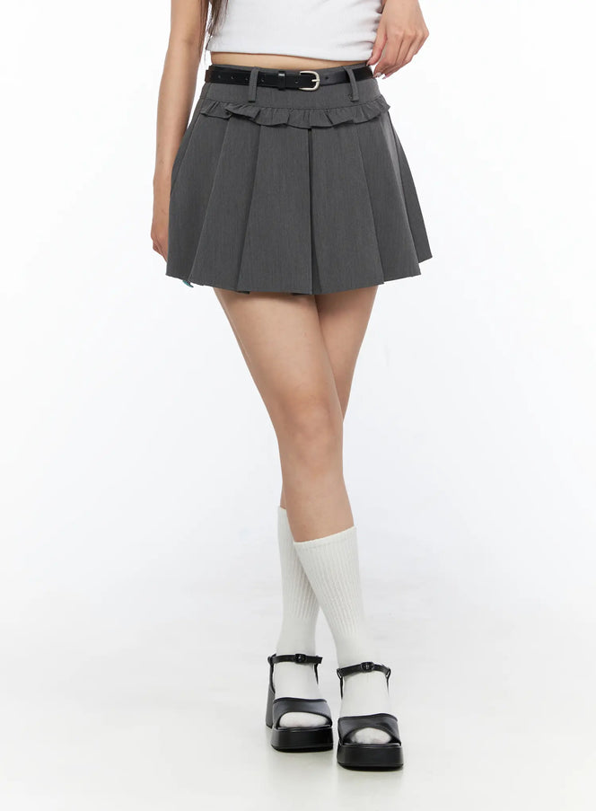 LEWKIN Pleated Mini Skirt CL517 Gray front close-up on model wearing white crop top, black belt detail, ruffle trim waistband, white knee socks and black platform sandals