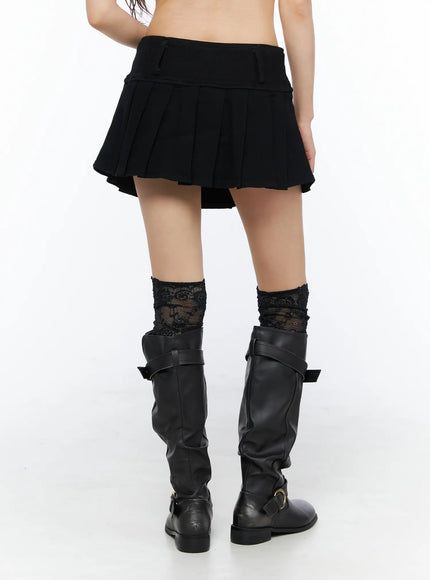 Pleated Mini Skirt CU530 Black back view on model with lace socks and black buckle boots, showing pleated skirt back and low waistband