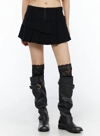 LEWKIN Pleated Mini Skirt CU530 Black front view on model wearing black boots and lace socks, layered flap detail with center back zipper