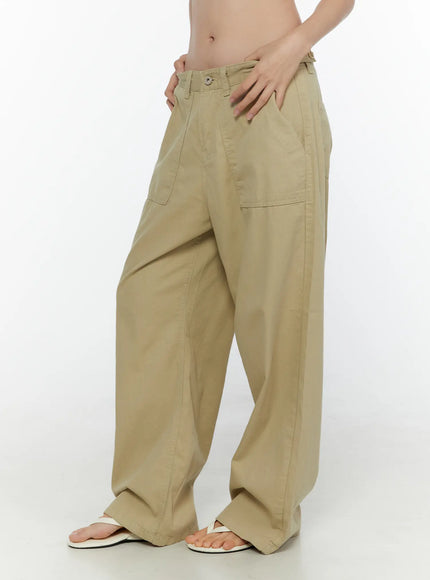 Pocket Detail Wide Leg Pants CL521 Beige side shot on model with hands on waistband, wide-leg cotton trousers with patch pockets, white flip-flops