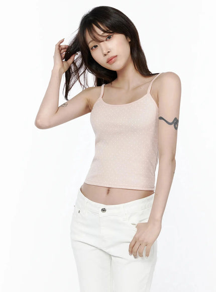Polka Dot Cami Tank Top IL506 Pink upper-body front shot on model raising hand to hair, direct gaze, showing spaghetti straps and ribbed polka dot crop top