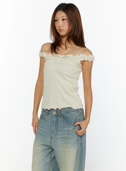 Polka Dot Frill Tank Top CL515 Cream front model shot worn off-shoulder with blue wide-leg jeans, ruffled neckline and satin bow detail