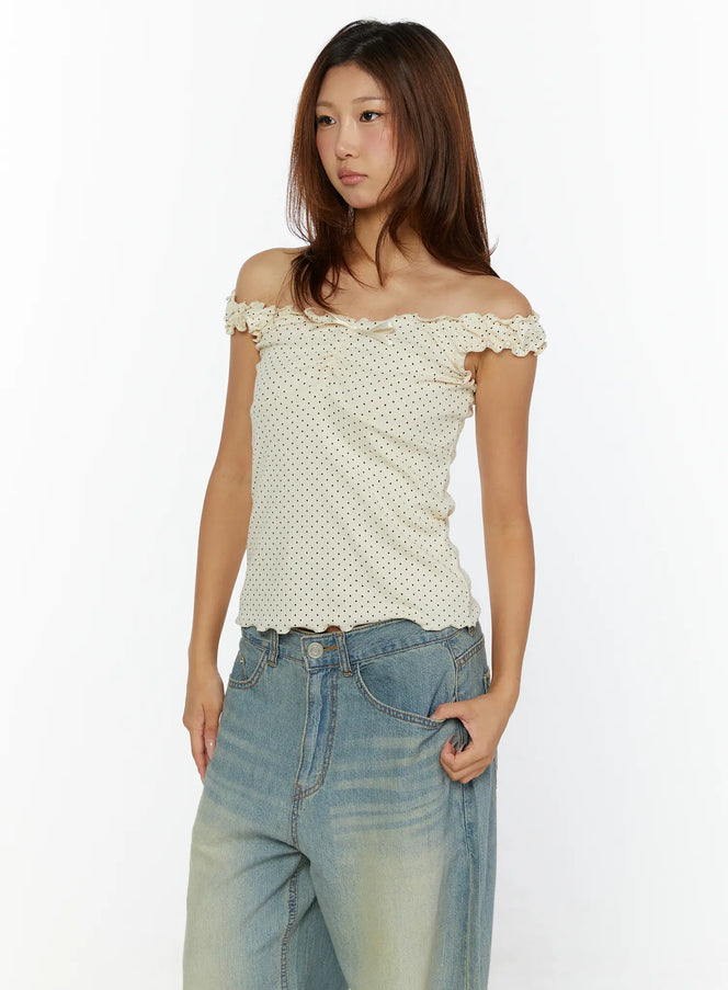 Polka Dot Frill Tank Top CL515 Cream front model shot worn off-shoulder with blue wide-leg jeans, ruffled neckline and satin bow detail