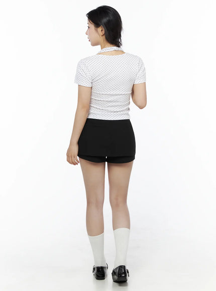 Polka Dot Halter Layered Tee IU525 White back shot on model, polka dot fabric texture, cut-out halter strap at neckline, cropped fit with black mini skort