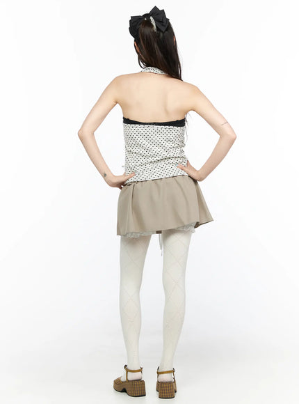 Polka Dot Halter Tank CL523 White back shot on model showing open bare back halter neck tie and black dot pattern with beige flared mini skirt and white tights