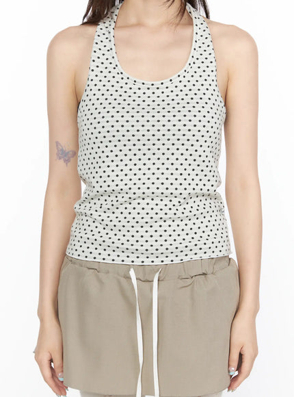 Polka Dot Halter Tank CL523 White close-up front shot on model showing scoop neckline racerback strap detail and black polka dot ribbed knit texture with beige shorts