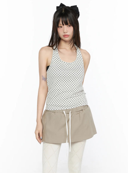 LEWKIN Polka Dot Halter Tank CL523 White front shot on model wearing black dot pattern racerback halter top styled with beige mini skirt and white tights