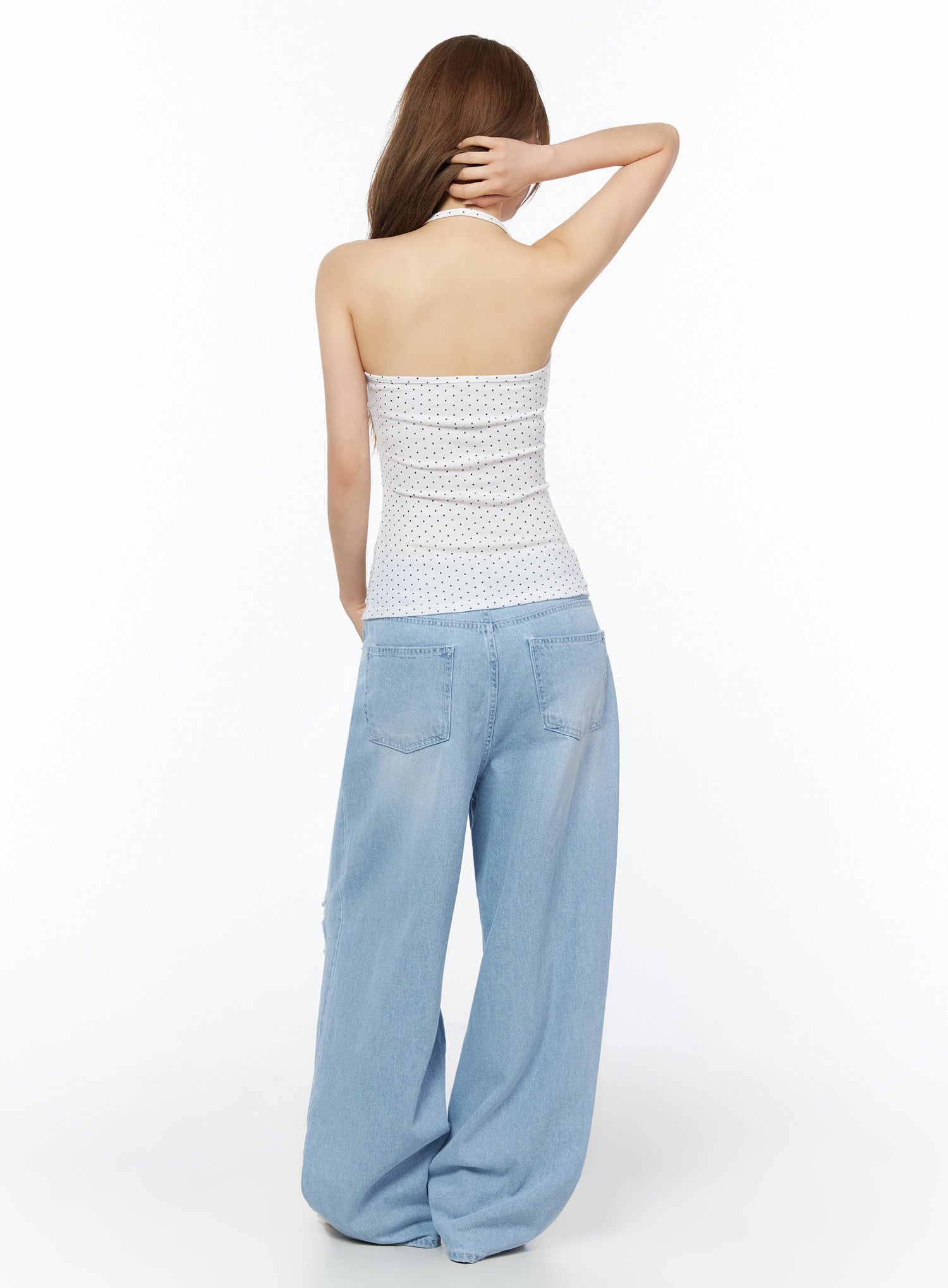 Polka Dot Halter Top IL502 White back shot on model with hand in hair revealing open-back halter design and crossover neck strap