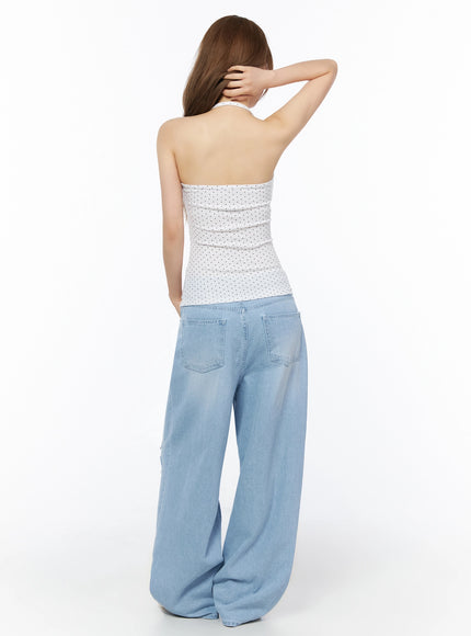 Polka Dot Halter Top IL502 White back shot on model with hand in hair revealing open-back halter design and crossover neck strap