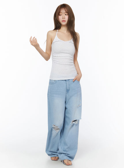 Polka Dot Halter Top IL502 White full-length front shot on model with one hand raised styled with ripped wide-leg denim