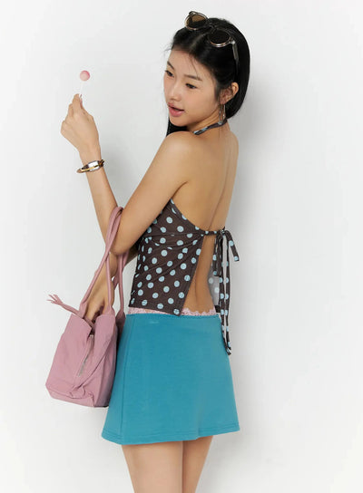 LEWKIN Polka Dot Halter Top IL509 Brown back shot on model holding lollipop with pink bag, open-back tie detail, paired with teal mini skirt
