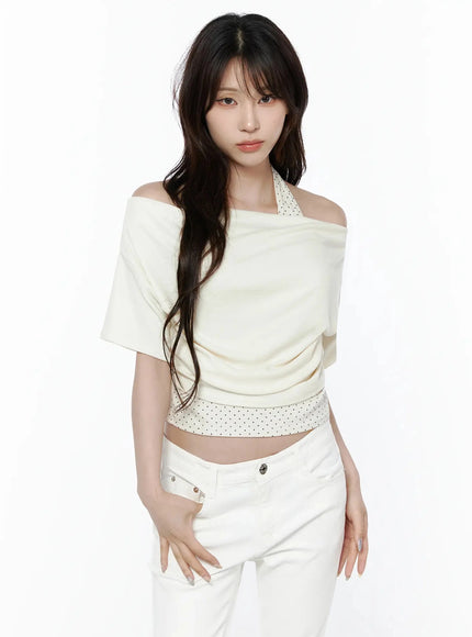 Polka Dot Layered Halter Neck T-Shirt IL506 Ivory front model shot standing straight showcasing off-shoulder drape and polka dot halter strap with white jeans