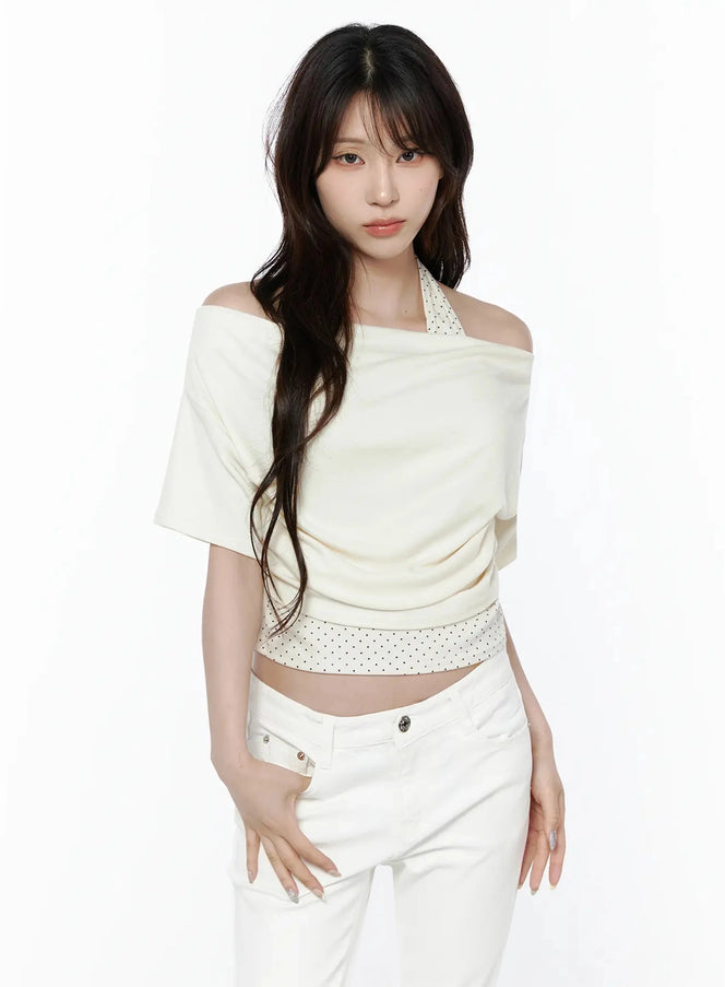 Polka Dot Layered Halter Neck T-Shirt IL506 Ivory front model shot standing straight showcasing off-shoulder drape and polka dot halter strap with white jeans