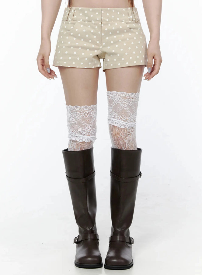 LEWKIN Polka Dot Mini Shorts IL506 Beige front close-up on model showing white polka dot pattern, belt loops, and white lace thigh-high socks with dark riding boots