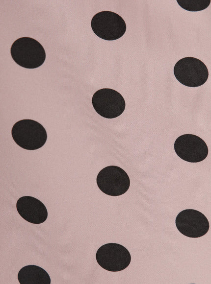 Polka Dot Mini Skirt CL503 close-up fabric detail showing large black polka dots on dusty pink smooth stretch material texture