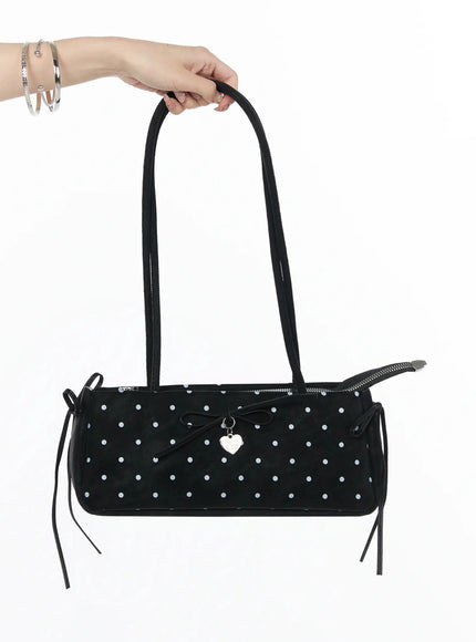 LEWKIN Polka Dot Ribbon Shoulder Bag IL523 Black hand-held shot model hand gripping dual straps of cylindrical polka dot bag with bow charm and side tie details