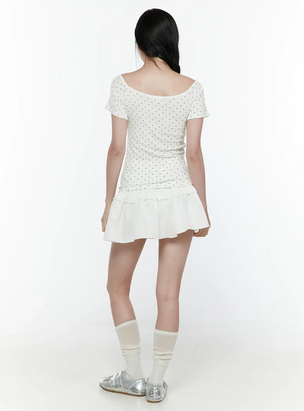 Polka Dot Round Shoulder Top IL506 White back model shot showing wide scoop back neckline, black polka dot short-sleeve top with fitted silhouette and layered white ruffle mini skirt hem