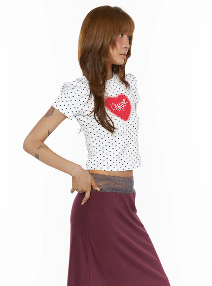 Polka Dot Slim Top CL503 White three-quarter front view on model showing L'Amour heart graphic detail, puff shoulder sleeve, cropped hem with lace trim
