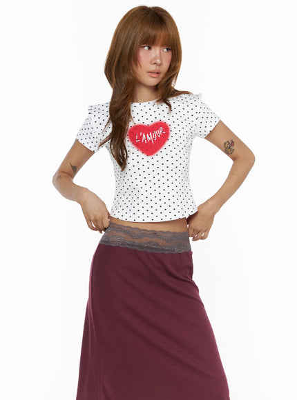 Polka Dot Slim Top CL503 White front view on model hands on waist showing fitted polka dot crop top with red fuzzy L'Amour heart, cropped length with lace hem