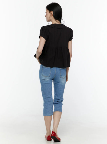 Puff Sleeve Blouse IL506 Black back full-body shot on model showing relaxed back hemline, peplum flare, and puff sleeves, paired with blue cropped jeans and red flats
