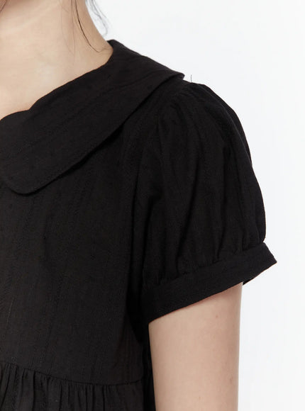 Puff Sleeve Blouse IL506 Black detail close-up of peter pan collar and puff sleeve on model, showing rounded collar edge, gathered sleeve cap, and woven stripe texture